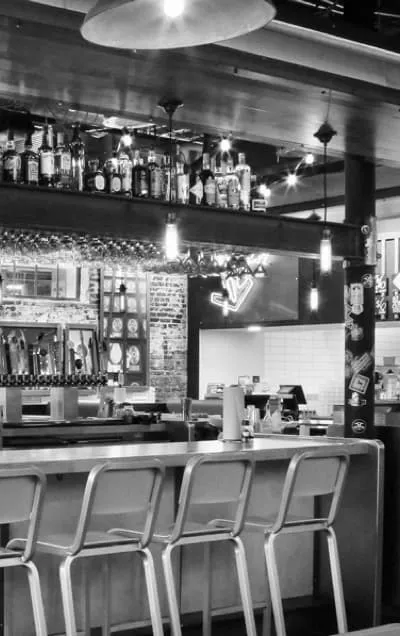 A black and white photo of the bar area inside a Hopdoddy restaurant.
